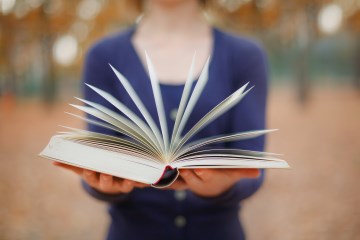 ragazza tiene libro aperto